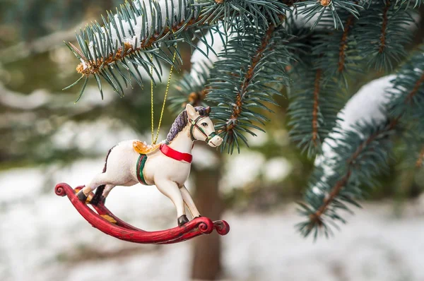 Rocking horse and snowy pine tree decorated for Christmas toy — Stock Photo, Image