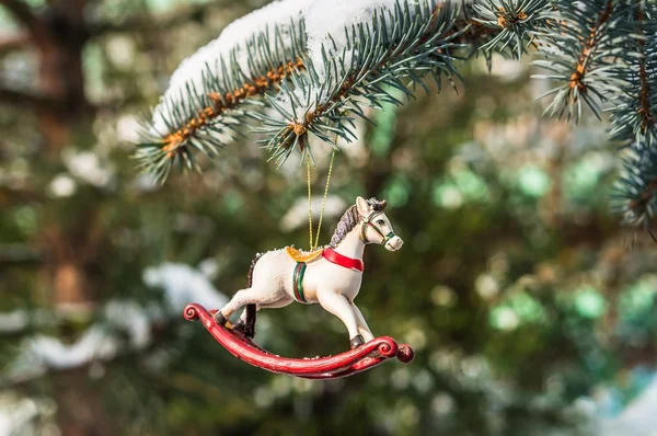 Rocking horse and snowy pine tree decorated for Christmas toy — Stock Photo, Image