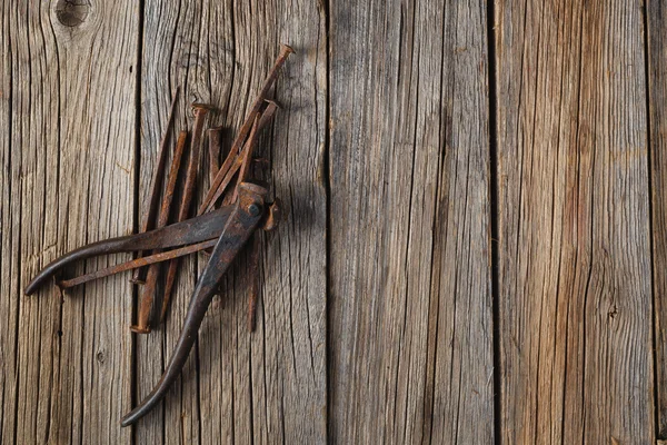 Clavos viejos y cortadora en mesa de madera rústica — Foto de Stock