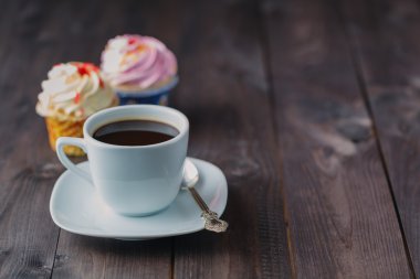 Cupcake and coffee on dark rustic table