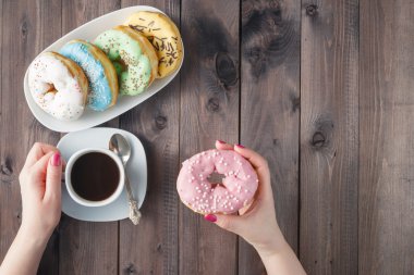 Woman eat donut and drink coffee, breakfast concept