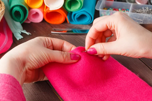 Primer plano de las manos de la mujer cosiendo juguete hecho a mano rosa —  Fotos de Stock