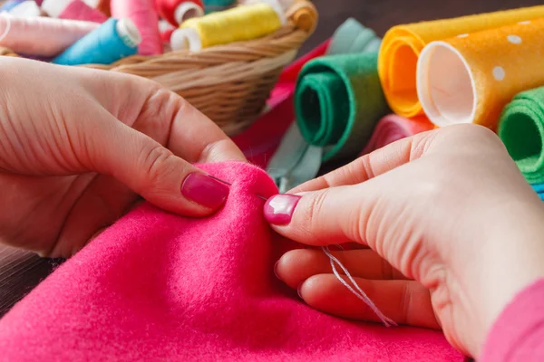 Closeup of woman hands sewing pink hamdmade toy — Zdjęcie stockowe