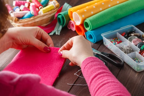 Primer plano de las manos de la mujer cosiendo juguete hecho a mano rosa —  Fotos de Stock