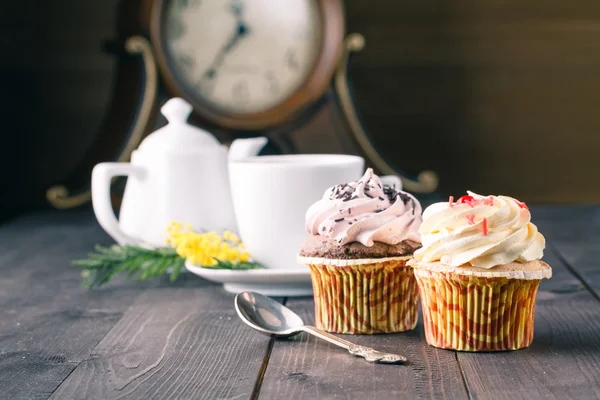 Cupcakes e xícara de tra no fundo de madeira escura — Fotografia de Stock