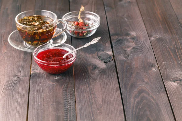 Чашка чая на деревянном столе на деревянном фоне с малиной — стоковое фото