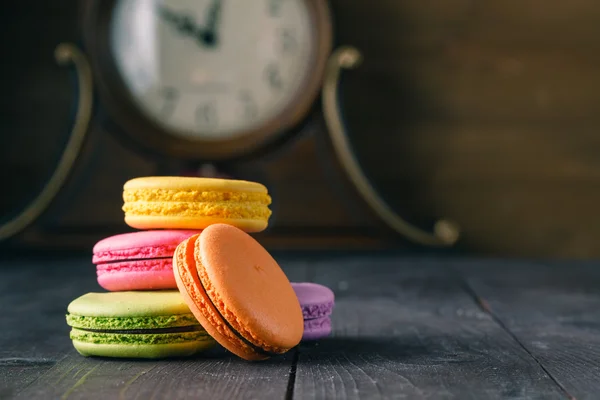 Söta och färgglada macaroon cookies torn på mörk bakgrund — Stockfoto