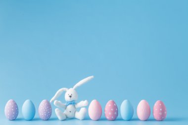 mavi arka plan üzerinde bir satırda Paskalya yumurtaları