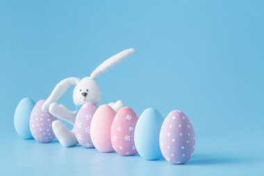 mavi arka plan üzerinde bir satırda Paskalya yumurtaları