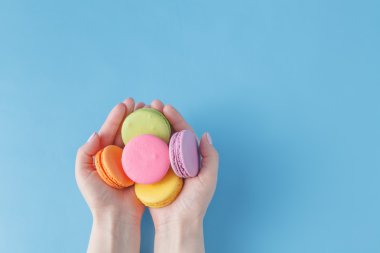 Renkli Fransız macarons elinde tutan kız