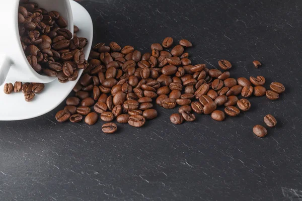 Чашка з кавовими зернами на темному фоні — стокове фото