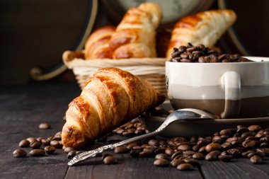 Ahşap masa üzerinde taze kruvasan ve kahve Servis Kahvaltı