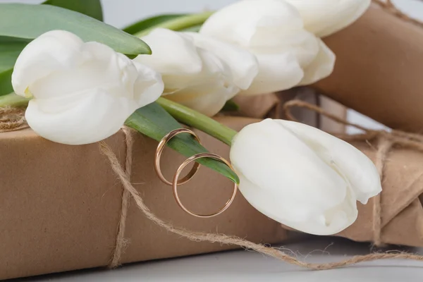 Confezione regalo e bouquet di tulipani su sfondo bianco — Foto Stock