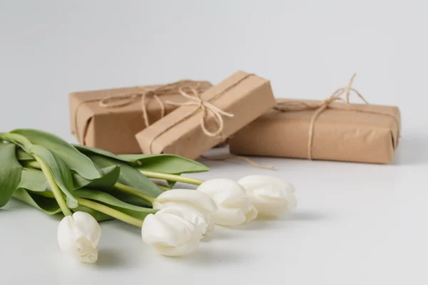 白色背景上的礼物盒子和郁金香花束 — 图库照片