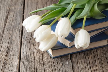 Kitap ve ahşap masaya çiçek