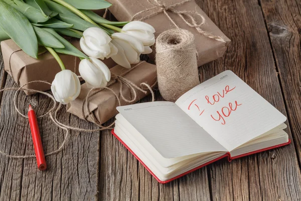 Eu te amo frase no caderno com flores na mesa — Fotografia de Stock