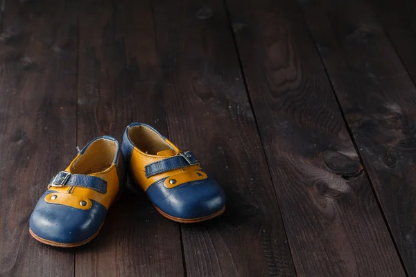 Pair of baby shoes on wooden table — Stock Photo, Image