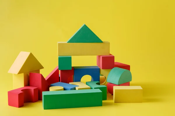 Building blocks on bright yellow background — Stock Photo, Image