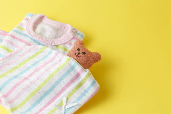 Baby clothing on a yellow background — Stock Photo, Image