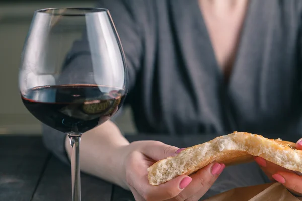 Handen van een vrouw breken en delen van brood — Stockfoto
