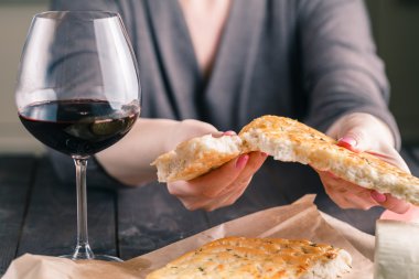masada oturan kadın bir boncuk ve bir kadeh kırmızı şarap sever