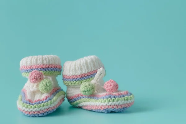 Annonce du nouveau-né. Chaussons bébé tricotés sur aquamarine unie b — Photo