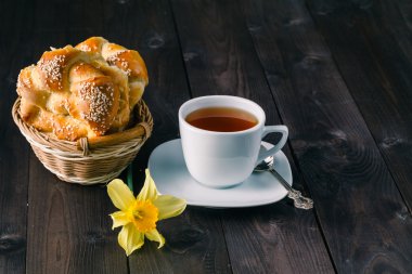 Masada çiçekler olan bir fincan çay.