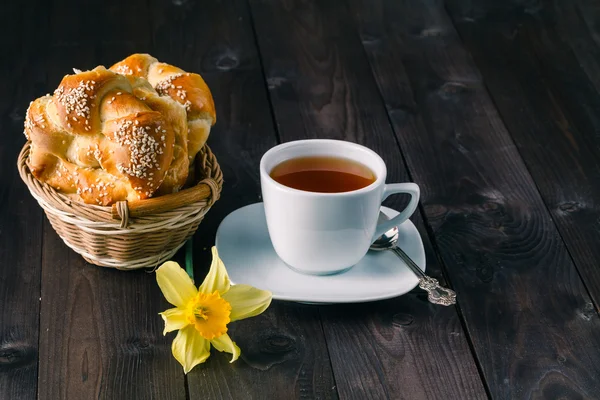 Masada çiçekler olan bir fincan çay.