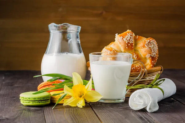 Молоко с выпечкой и весенний желтый цветок на столе — стоковое фото