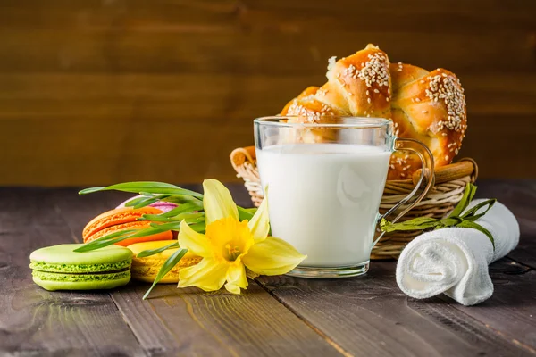 Milch mit Gebäck und Frühlingsblume auf dem Tisch — Stockfoto