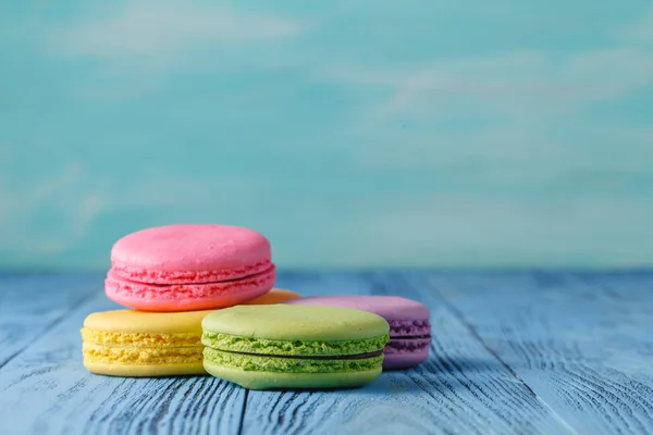 Lezzetli Fransız macarons mavi ahşap bir masa üzerinde — Stok fotoğraf