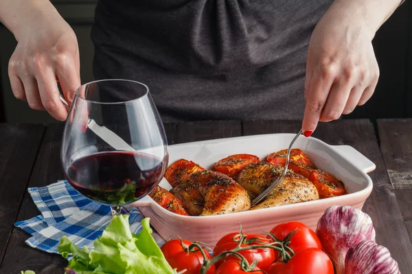 Woman puts roast chicken on the table — Stock Photo, Image