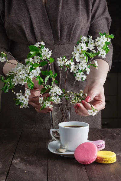 Taza de café y rama de flor de cerezo sobre un fondo oscuro — Foto de Stock