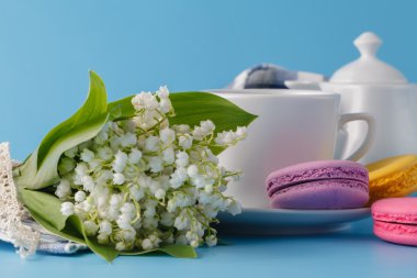 Mavi zemin üzerine beyaz çiçekli çay içme bahar