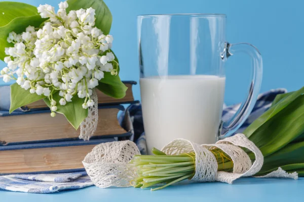 Mjölk glas på blå med blommor — Stockfoto