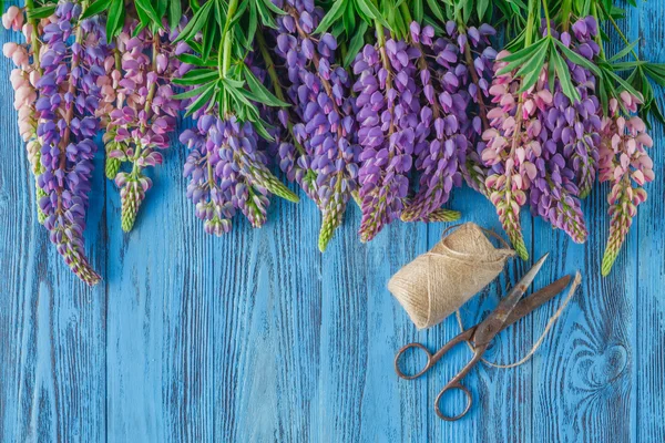 Blue wooden background with pink white lupines border and empty — Stock Photo, Image