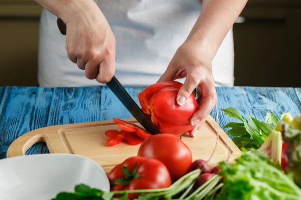 Cozinhando e conceito de casa - close-up de tomate corte da mão feminina — Fotografia de Stock