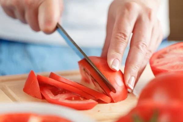 Tomates cortados en cubitos en una tabla de cortar — Foto de Stock