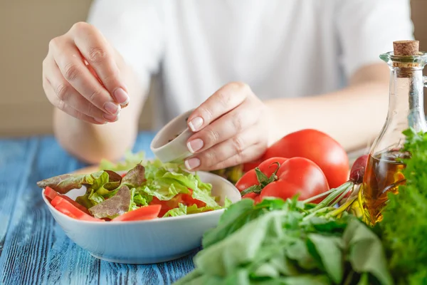 Женские руки добавляют специи для овощного салата — стоковое фото