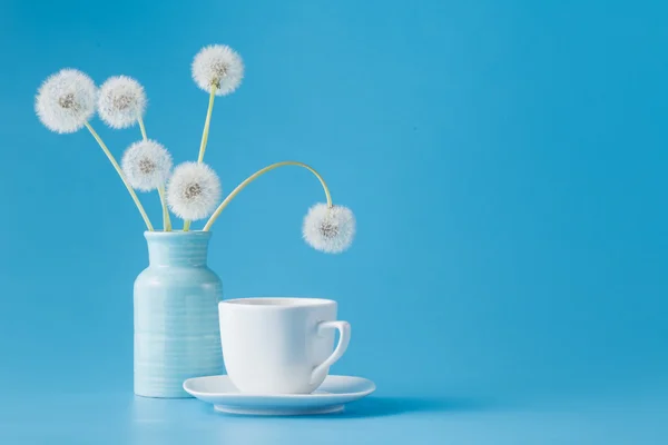 Pissenlits et tasse de thé sur bleu — Photo