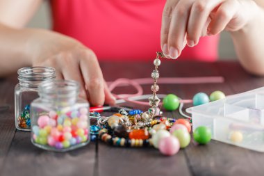 Kadının el bracelete ile plastik boncuk yapma