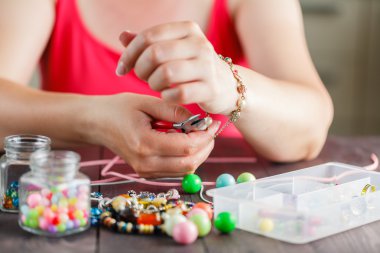 Kadının el bracelete ile plastik boncuk yapma
