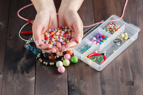 Hermosas manos con cuentas de colores — Foto de Stock