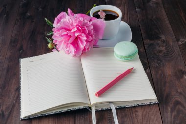 Ahşap arka plan üstünde defter ile kahve