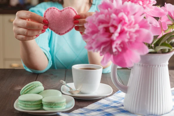 Mujer beber café y sosteniendo en las manos forma de corazón suave — Foto de Stock