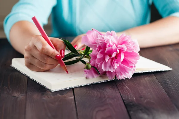 Peonie rosa nelle mani della donna sul tavolo di legno invecchiato — Foto Stock
