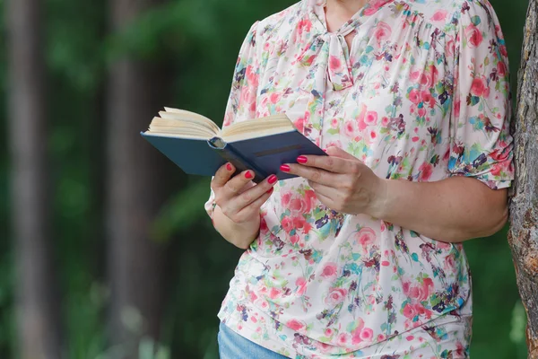 Жінка в літньому парку читає книгу — стокове фото