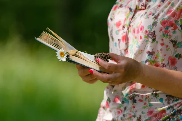Доросла жінка читає книгу на зеленому лузі — стокове фото