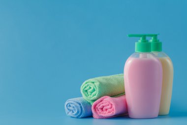renkli havlu ve mavi arka plan üzerinde sıvı sabun