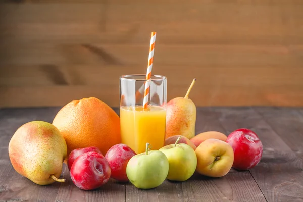 Saft im Glas und Früchte auf rustikalem Tisch — Stockfoto